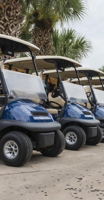 Cropped image of a line of golf carts in a parking lot.