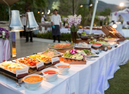 A buffet table with various foods.