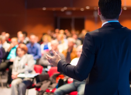 Person giving a speech to a crowd at a convention center